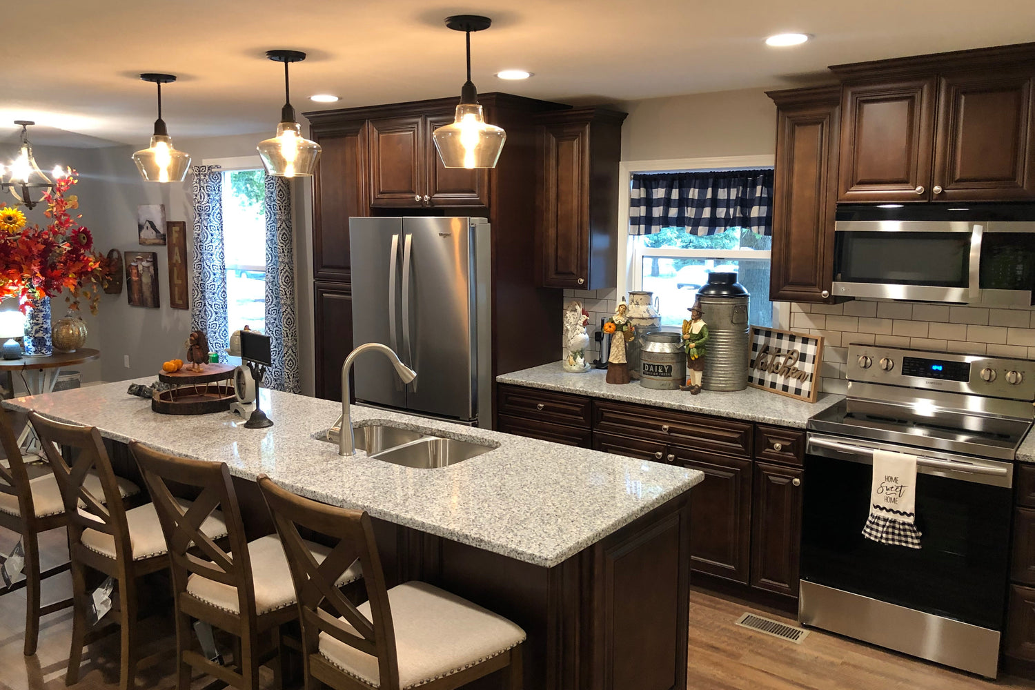 Modern kitchen with stainless steel appliances, wooden cabinets, and a breakfast bar.