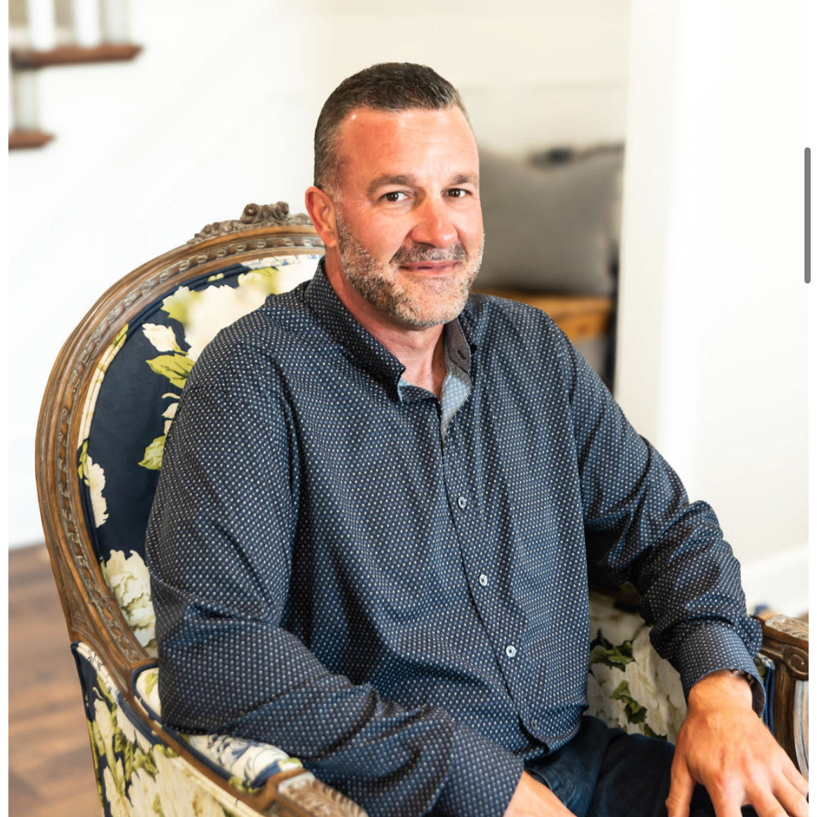 Jason sitting on a decorative chair in a home setting
