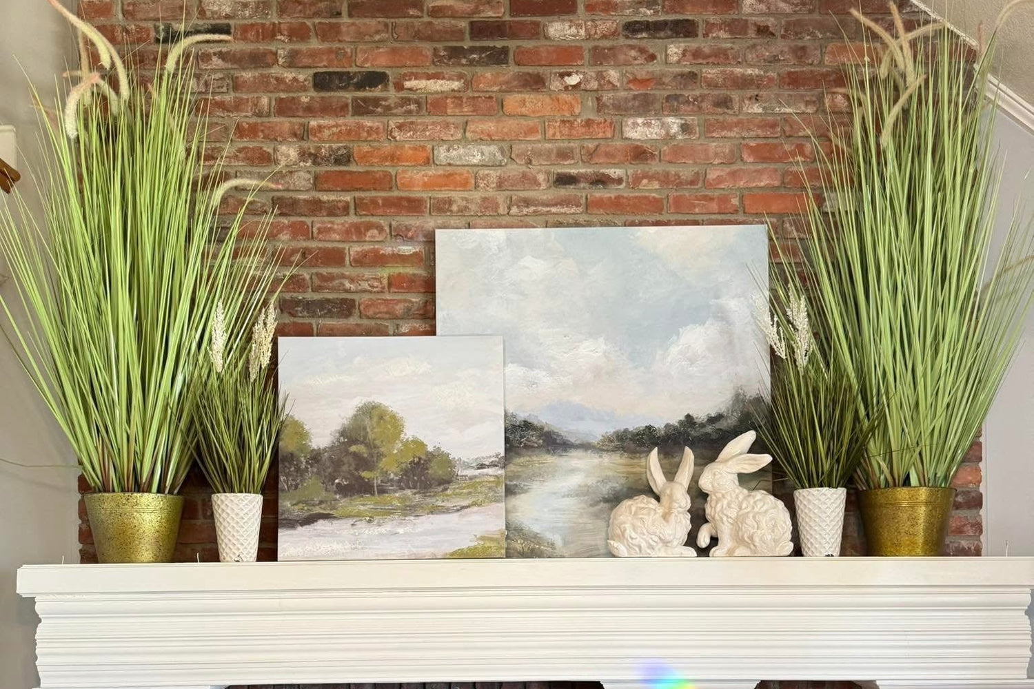 Brick fireplace with white mantel, decorative items, and plants.