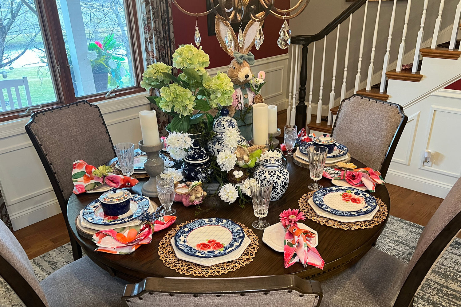 Dining table set for a meal with floral centerpieces and place settings in a home setting.