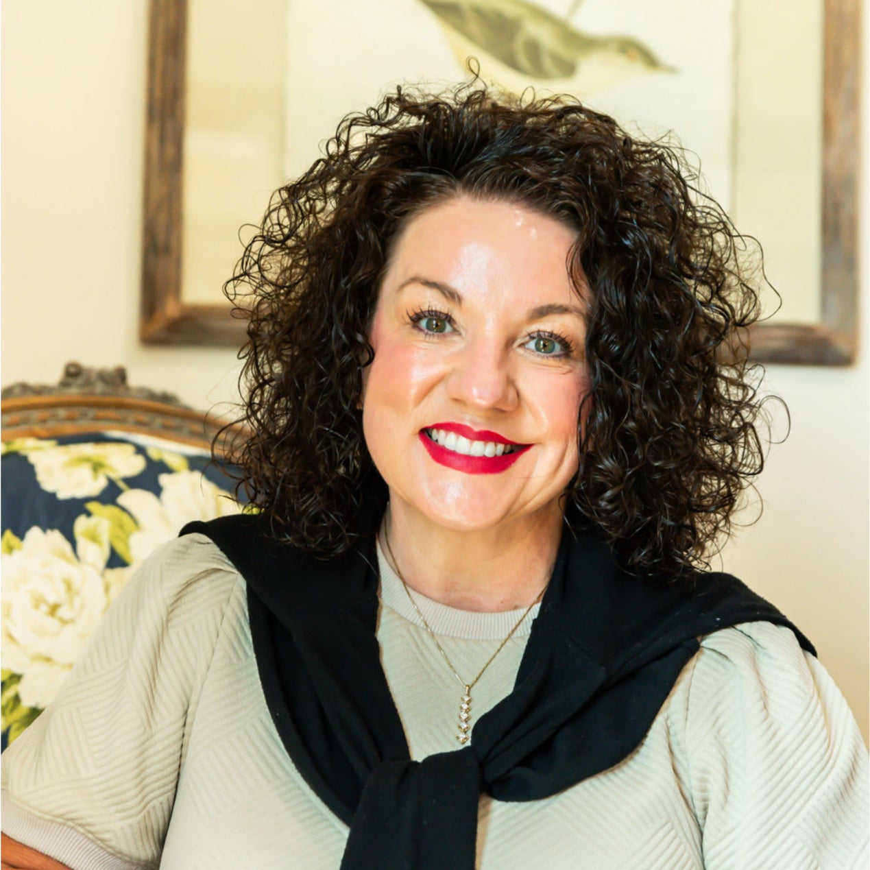 Tabitha wearing a black sweater in a room with a framed picture on the wall.